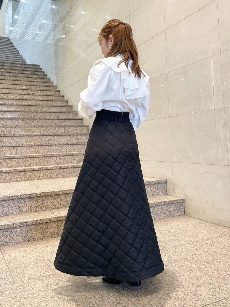 ホワイト系のシャツ/ブラウス、ブラック系のブーツ、ブラック系のスカートを着用したレディースの秋コーディネートの4枚目の写真