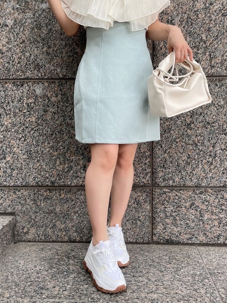 ホワイト系のニット/セーター、ブルー系のスカート、ホワイト系のスニーカーを着用したレディースの夏コーディネートの5枚目の写真