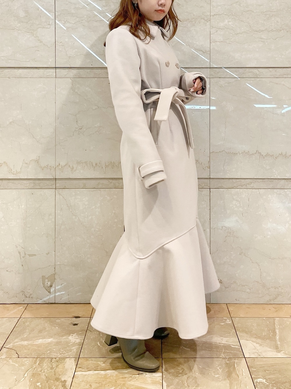 ブラウン系のブーツ、ホワイト系のその他アウター、ブルー系のニット/セーターを着用したレディースの冬コーディネートの2枚目の写真