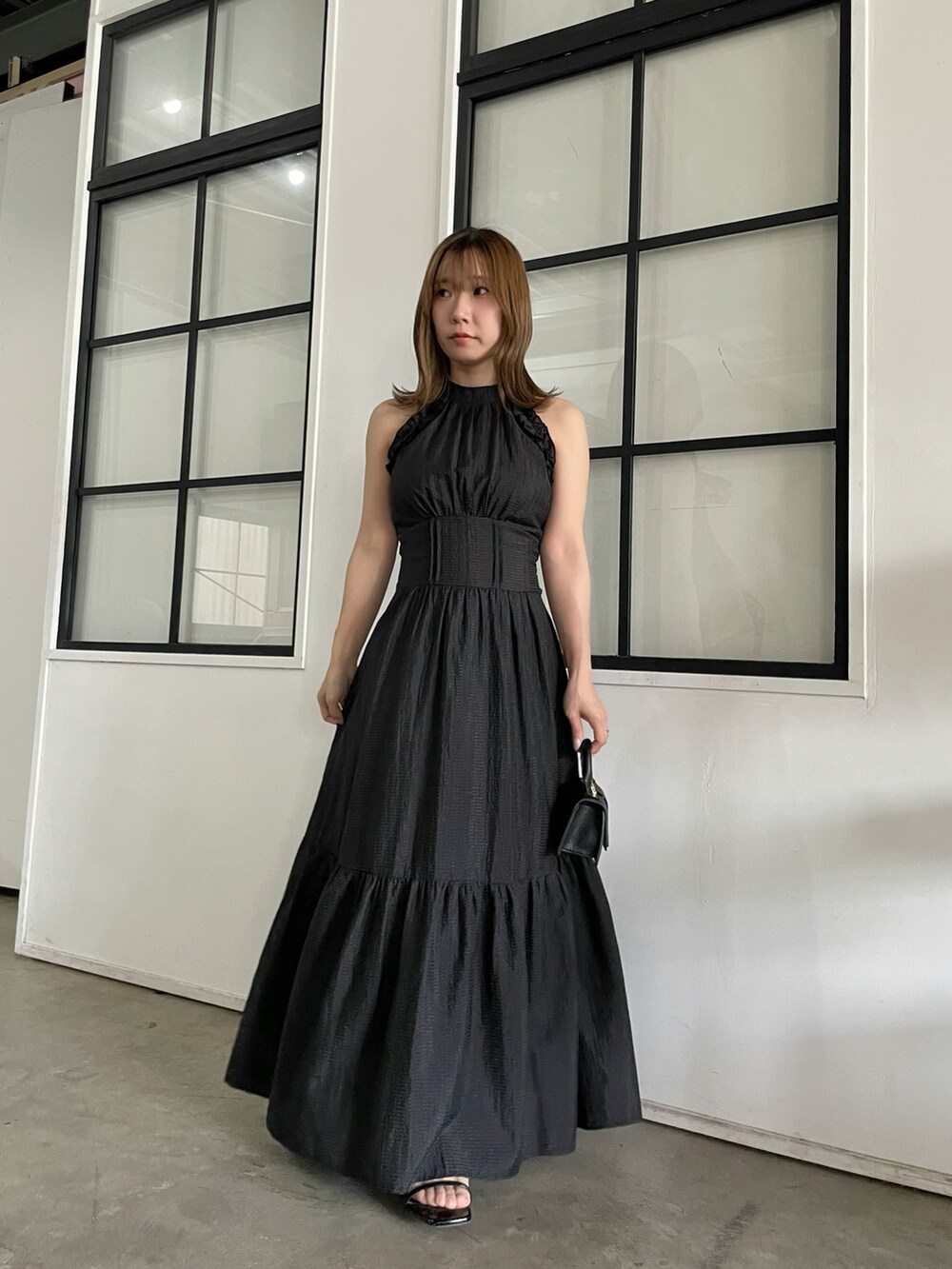 ブラック系のサンダル、ブラック系のワンピースを着用したレディースの春コーディネートの2枚目の写真