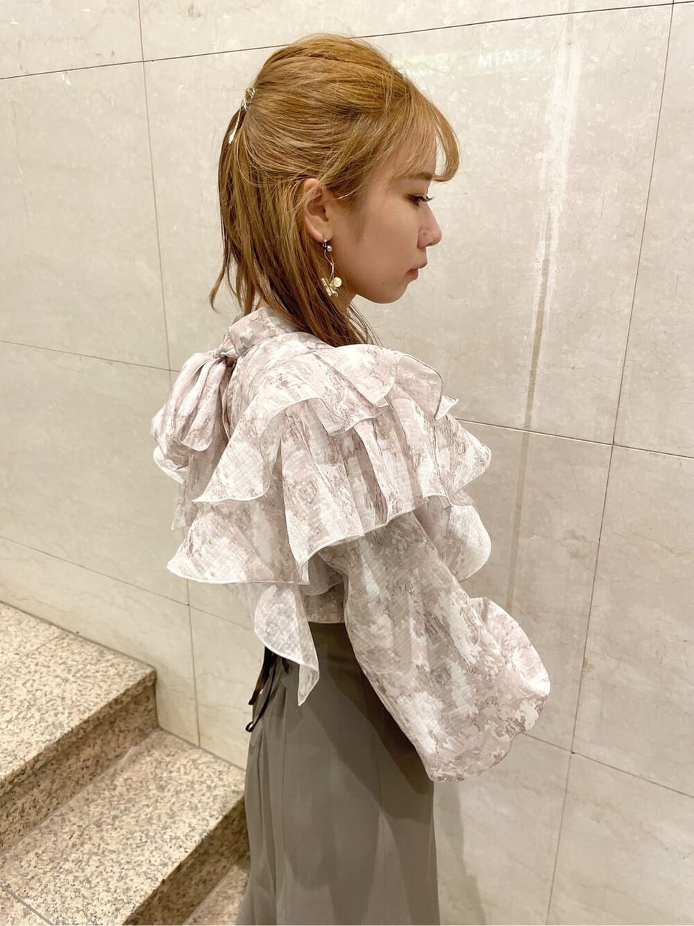 ブラック系のブーツ、ベージュ系のスカート、ベージュ系のシャツ/ブラウスを着用したレディースの秋コーディネートの6枚目の写真