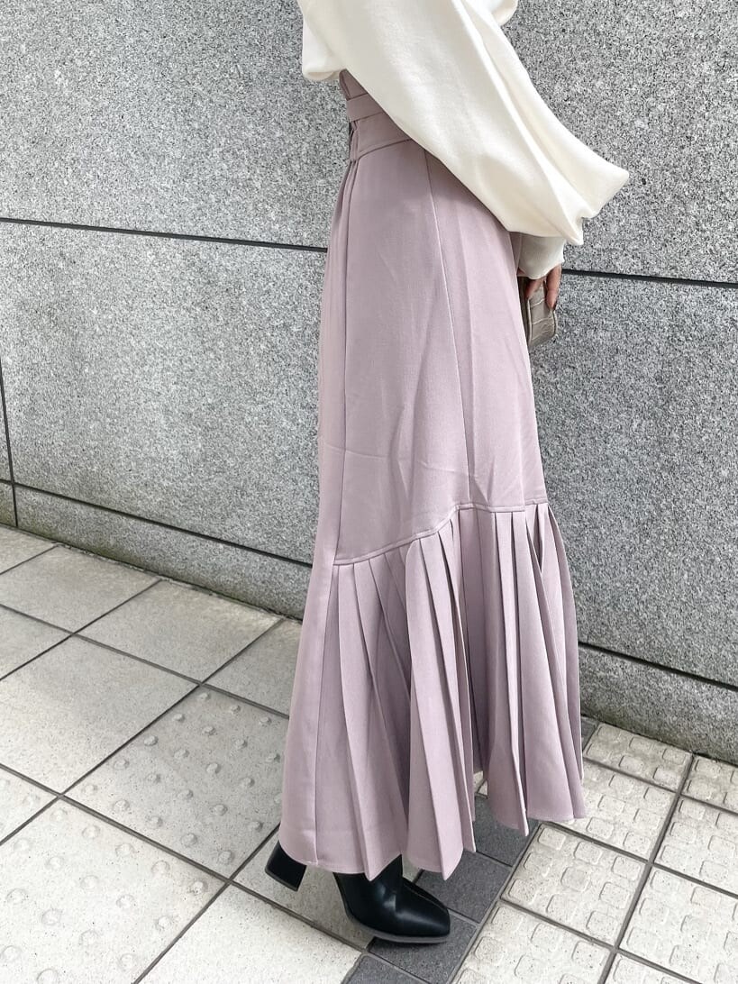 ベージュ系のスカート、ブラック系のブーツ、ホワイト系のキャミソールを着用したレディースの秋コーディネートの9枚目の写真