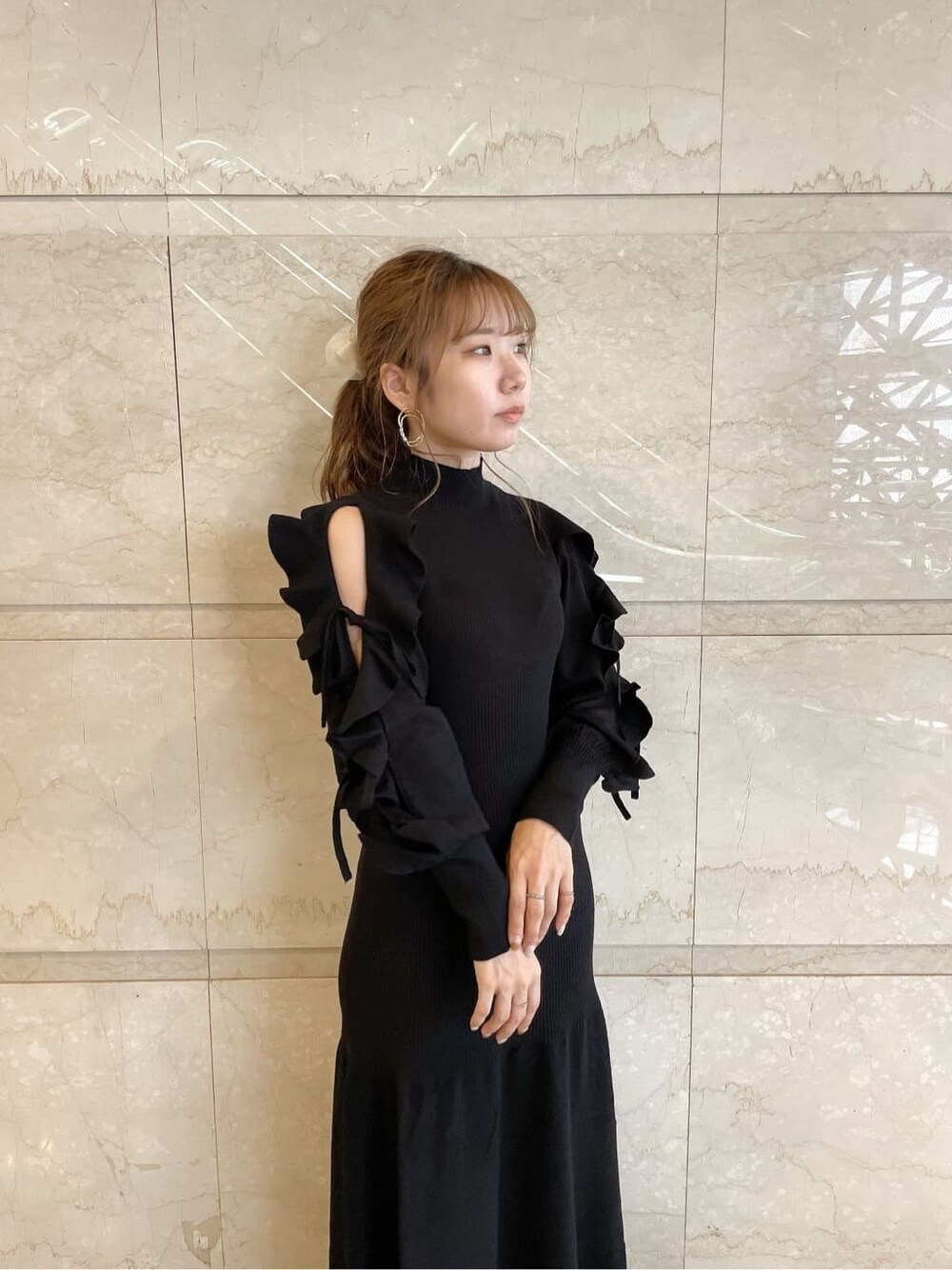 ベージュ系のブーツ、ブラック系のワンピース、ゴールド系のピアス（両耳用）を着用したレディースの秋コーディネートの5枚目の写真