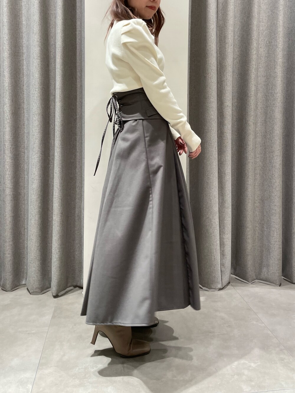 ホワイト系のニット/セーター、グレー系のスカート、ベージュ系のブーツを着用したレディースの冬コーディネートの4枚目の写真