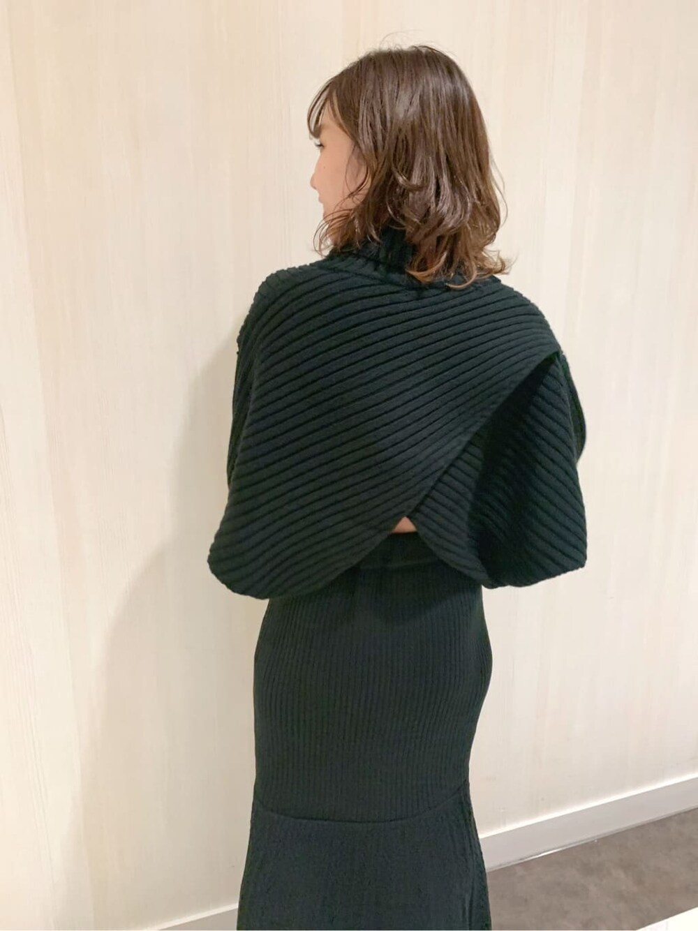 ブラック系のスカート、ブラック系のブーツ、ブラック系のニット/セーターを着用したレディースの秋コーディネートの5枚目の写真