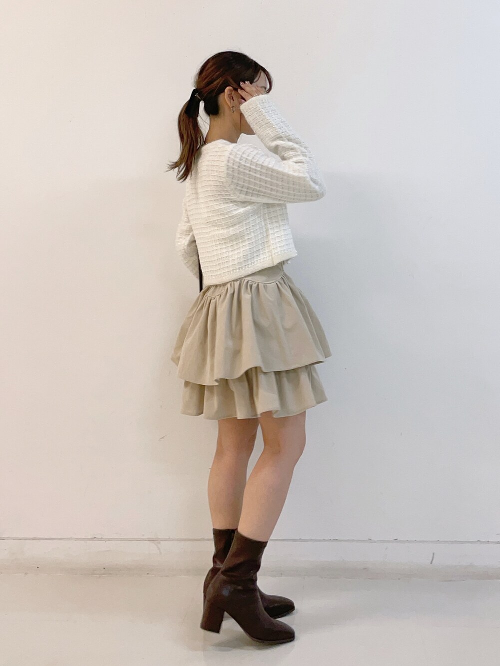 ホワイト系のカーディガン/ボレロ、ホワイト系のスカート、ブラウン系のショルダーバッグを着用したレディースの秋コーディネートの4枚目の写真