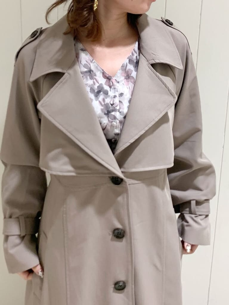 グレー系のトレンチコート、ピンク系のワンピース、ベージュ系のブーツを着用したレディースの秋コーディネートの10枚目の写真