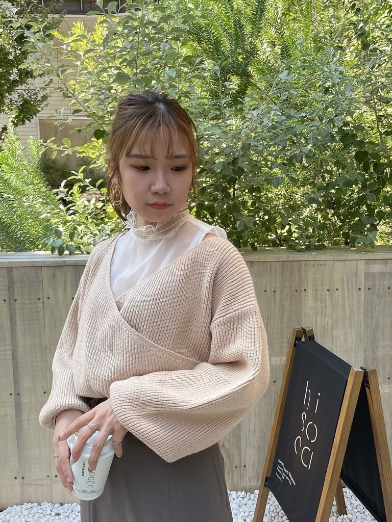 ベージュ系のニット/セーター、ベージュ系のスカート、ベージュ系のブーツを着用したレディースの秋コーディネートの6枚目の写真