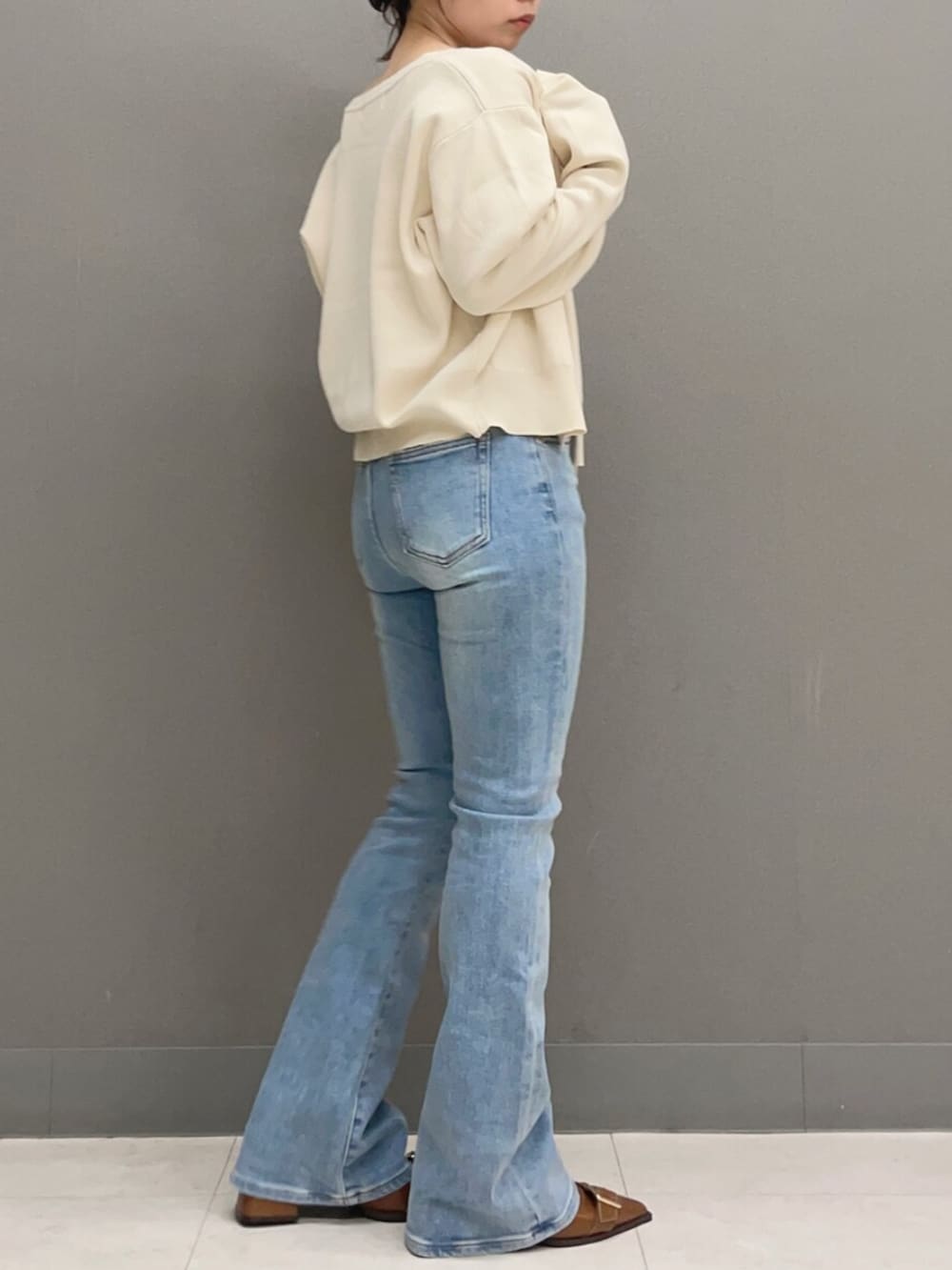 ホワイト系のキャミソール、ホワイト系のカーディガン/ボレロ、ブルー系のデニムパンツを着用したレディースの秋コーディネートの4枚目の写真