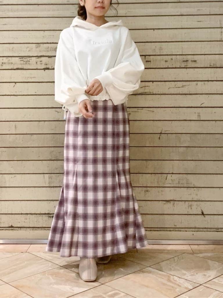 ホワイト系のパーカー、ベージュ系のブーツ、パープル系のスカートを着用したレディースの冬コーディネートの4枚目の写真