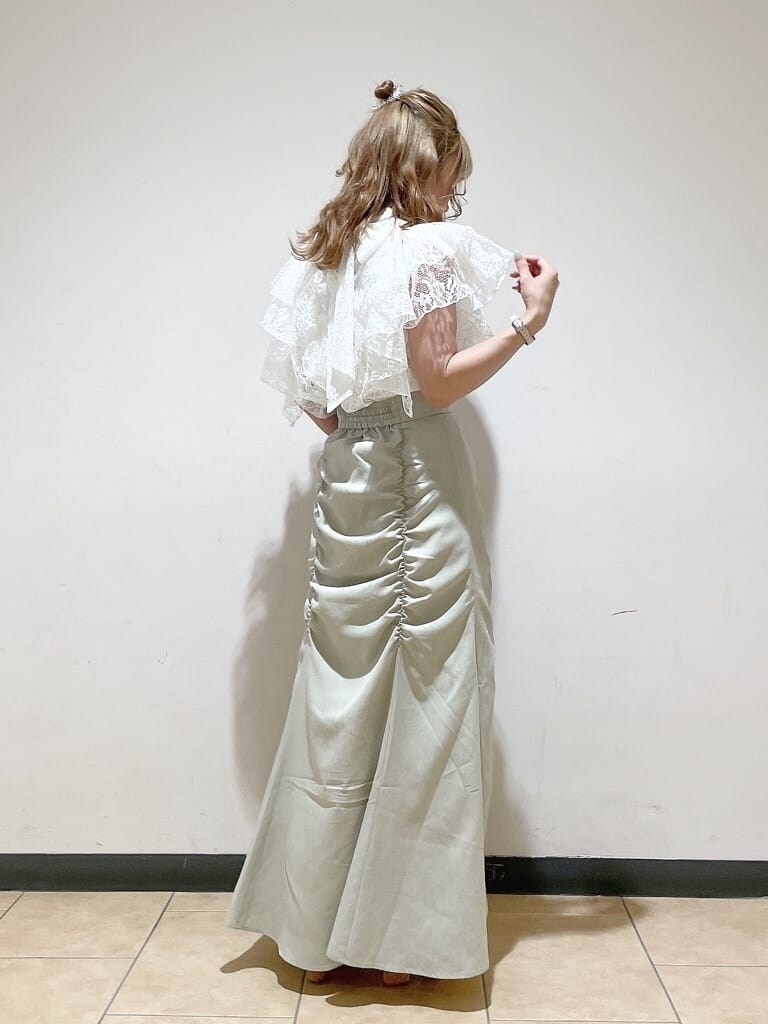 グリーン系のスカート、ブラウン系のハンドバッグ、ホワイト系のシャツ/ブラウスを着用したレディースの夏コーディネートの4枚目の写真