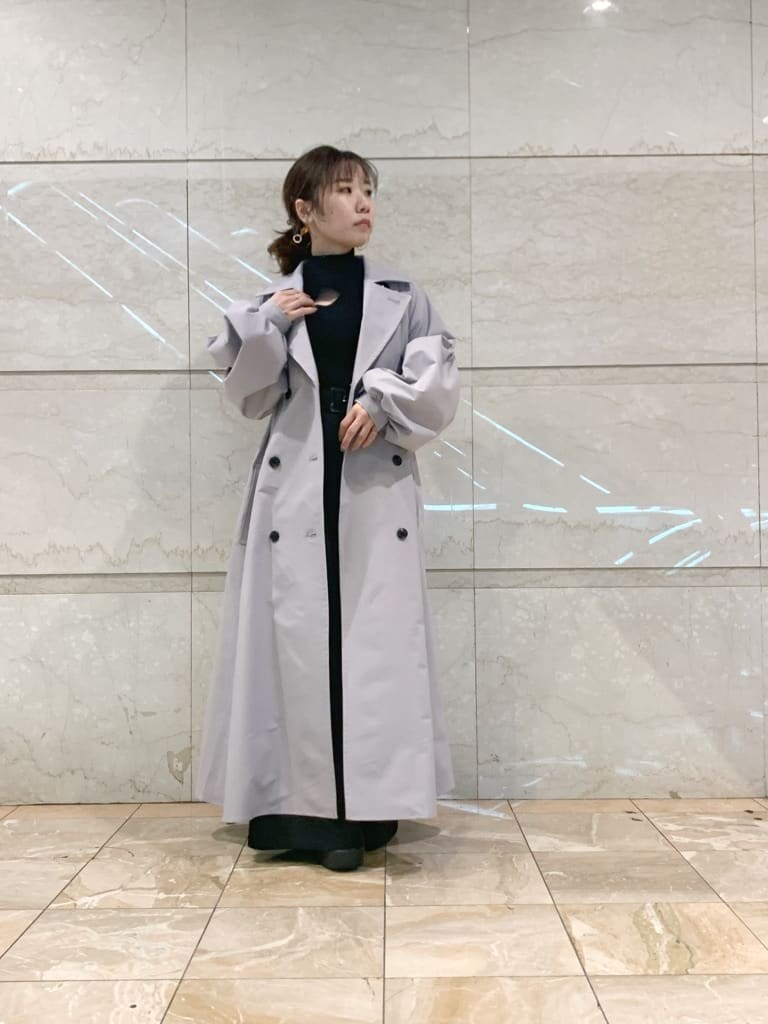 グレー系のトレンチコート、ブラック系のその他パンツ、ブラック系のローファーを着用したレディースの冬コーディネートの2枚目の写真