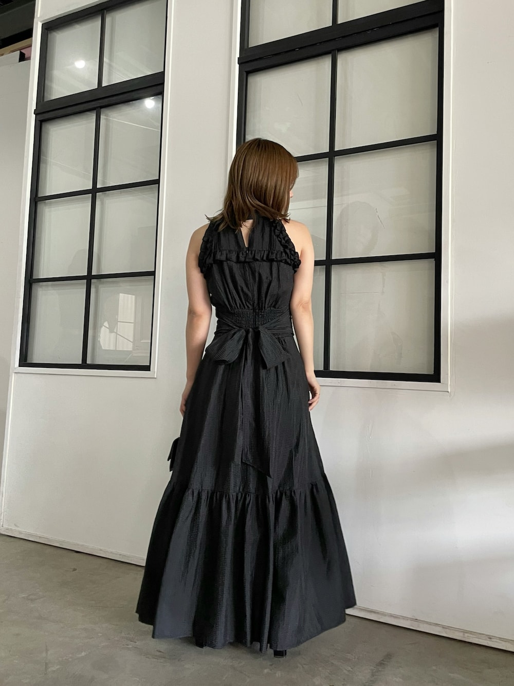 ブラック系のサンダル、ブラック系のワンピースを着用したレディースの春コーディネートの3枚目の写真