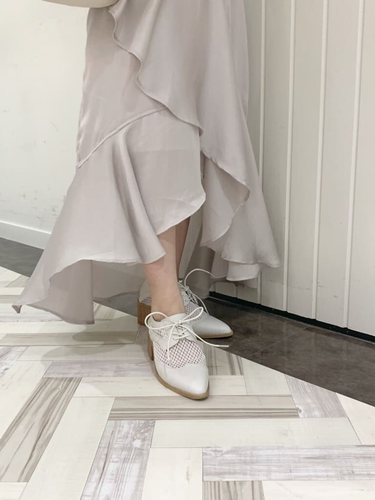 グリーン系のニット/セーター、グレー系のスカート、ホワイト系のローファーを着用したレディースの春コーディネートの9枚目の写真