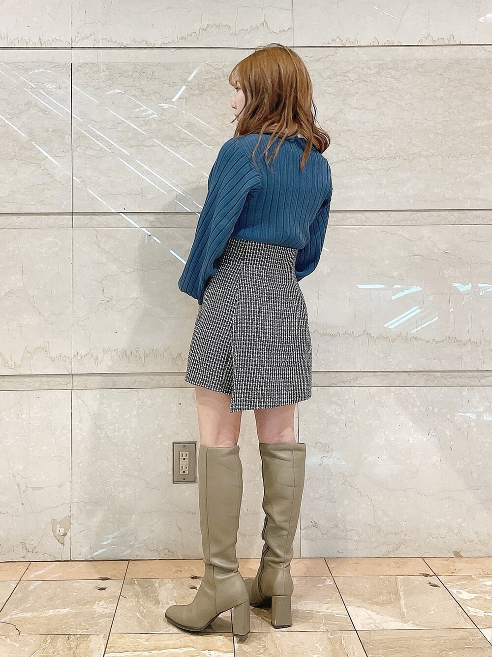 ブルー系のニット/セーター、ブラウン系のブーツ、ブルー系のスカートを着用したレディースの冬コーディネートの5枚目の写真