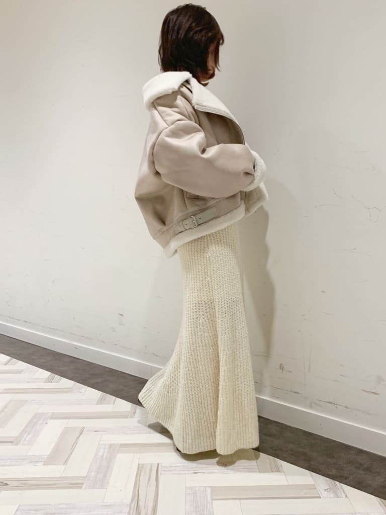 ホワイト系のワンピース、ホワイト系のブルゾン、ブラック系のブーツを着用したレディースの秋コーディネートの8枚目の写真