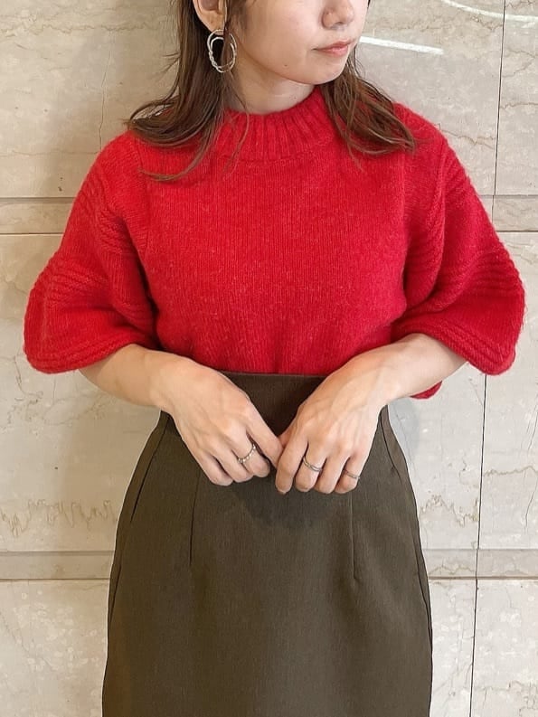 レッド系のニット/セーター、ブラウン系のスカート、ベージュ系のブーツを着用したレディースの秋コーディネートの6枚目の写真