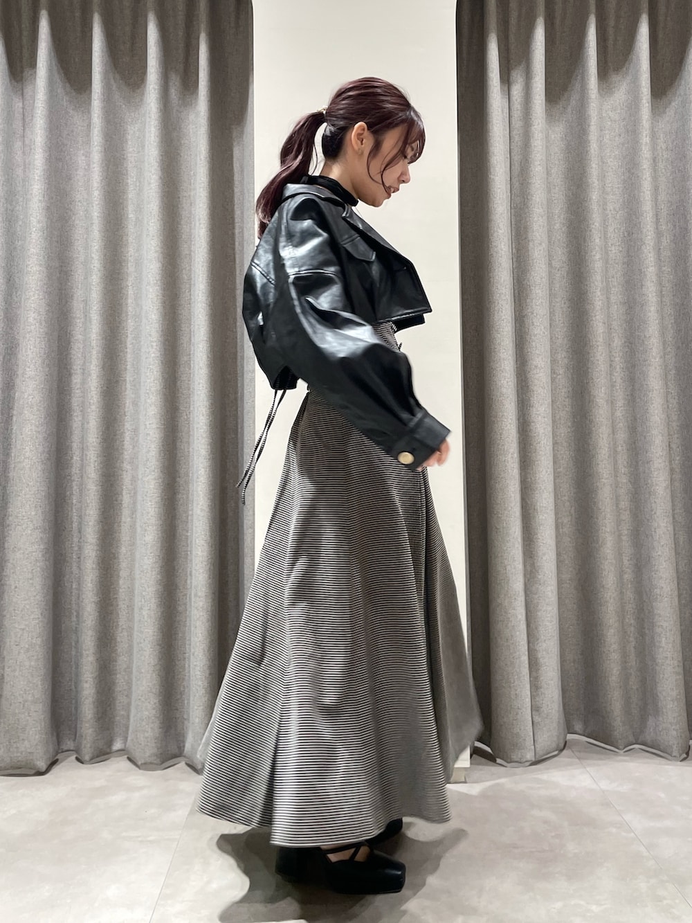 ブラック系のワンピース、ブラック系のパンプス、ブラック系のライダースジャケットを着用したレディースの秋コーディネートの3枚目の写真