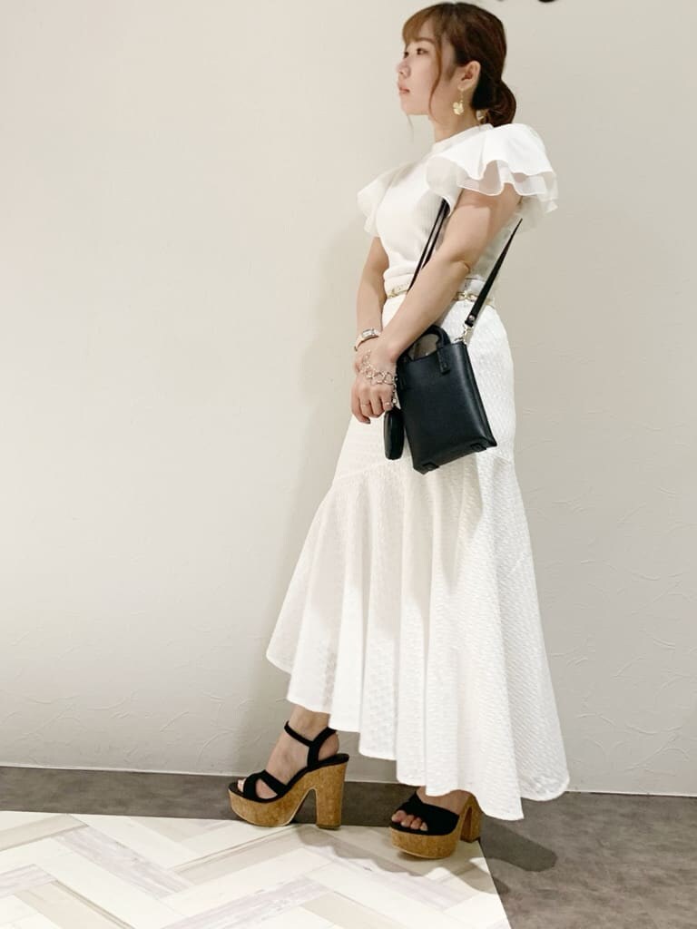 その他のサンダル、ブラック系のハンドバッグ、ホワイト系のTシャツ/カットソーを着用したレディースの夏コーディネートの3枚目の写真