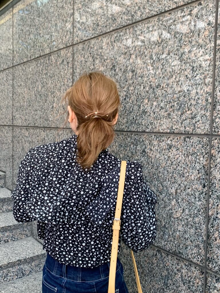 イエロー系のハンドバッグ、ベージュ系のテーラードジャケット、ブラック系のローファーを着用したレディースの冬コーディネートの5枚目の写真