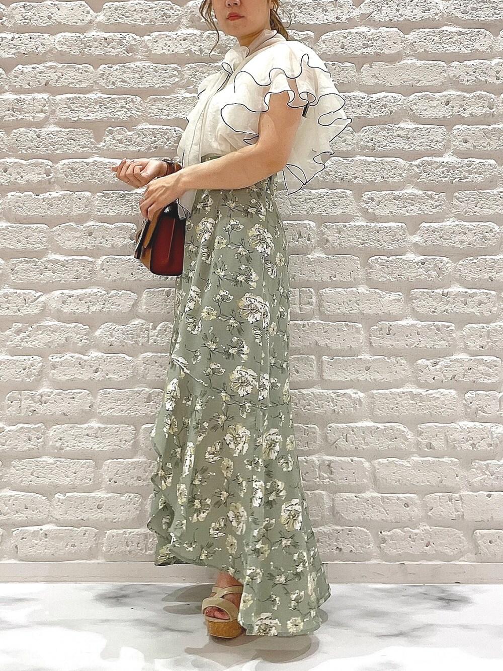 ホワイト系のサンダル、イエロー系のハンドバッグ、ホワイト系のシャツ/ブラウスを着用したレディースの夏コーディネートの3枚目の写真