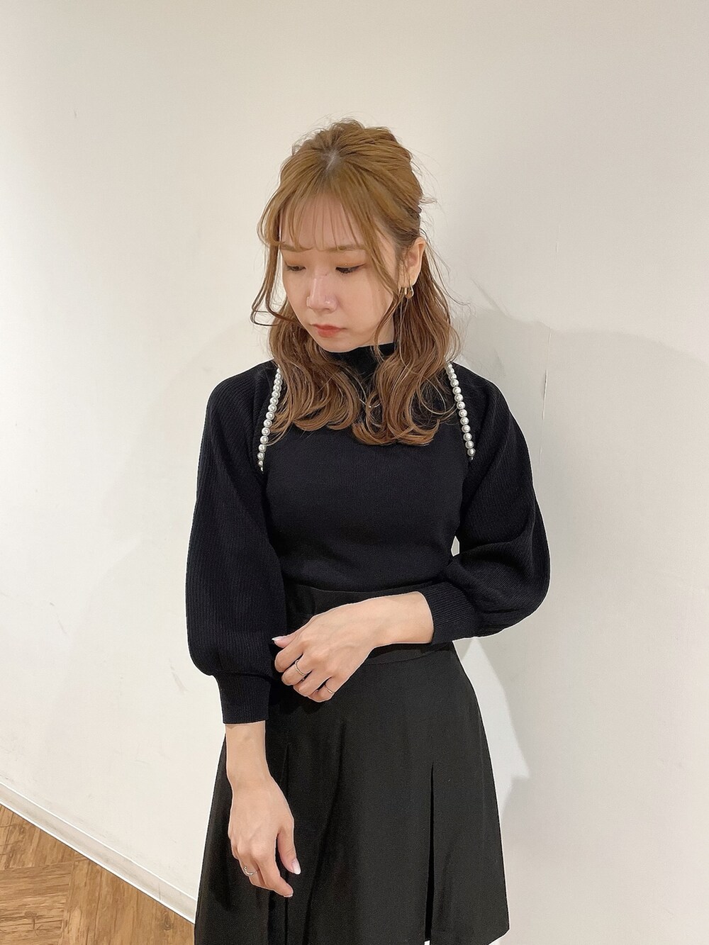 ブラック系のスカート、ブラック系のニット/セーター、ブラック系のブーツを着用したレディースの冬コーディネートの6枚目の写真