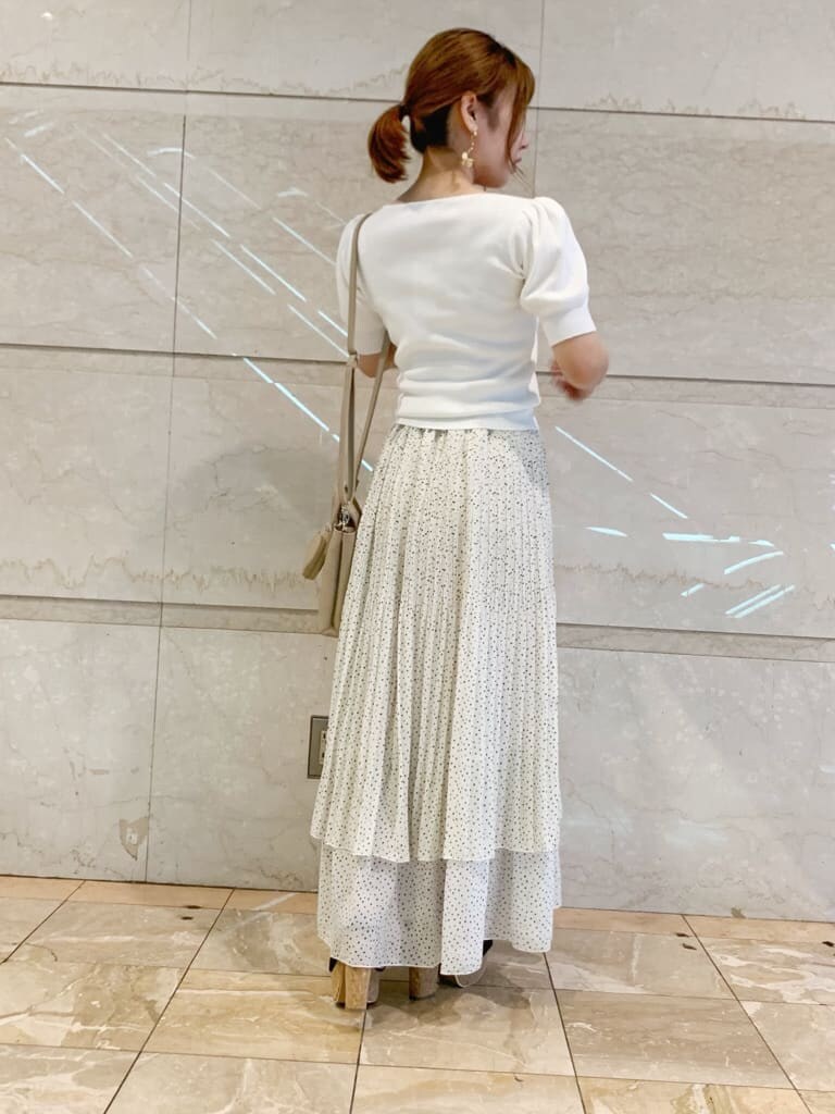 ブラック系のサンダル、ベージュ系のハンドバッグ、ホワイト系のニット/セーターを着用したレディースの夏コーディネートの4枚目の写真