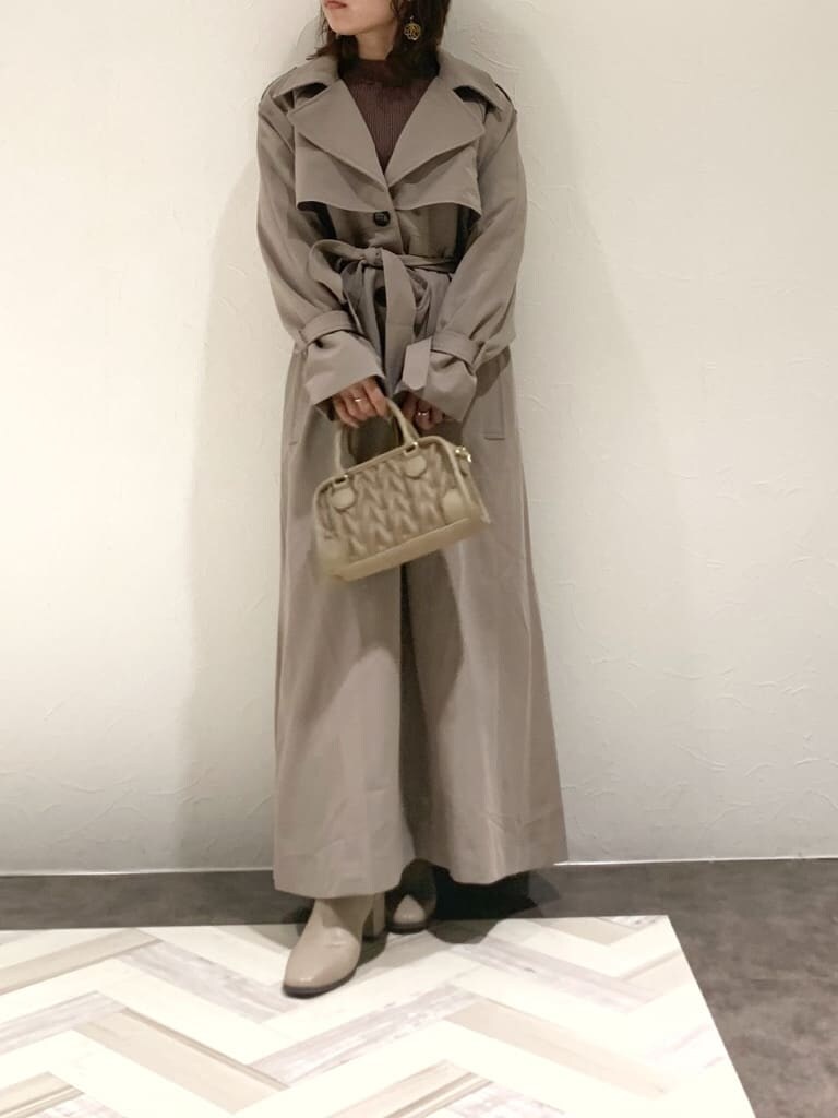 ブラウン系のワンピース、グレー系のトレンチコート、ベージュ系のハンドバッグを着用したレディースの秋コーディネートの8枚目の写真