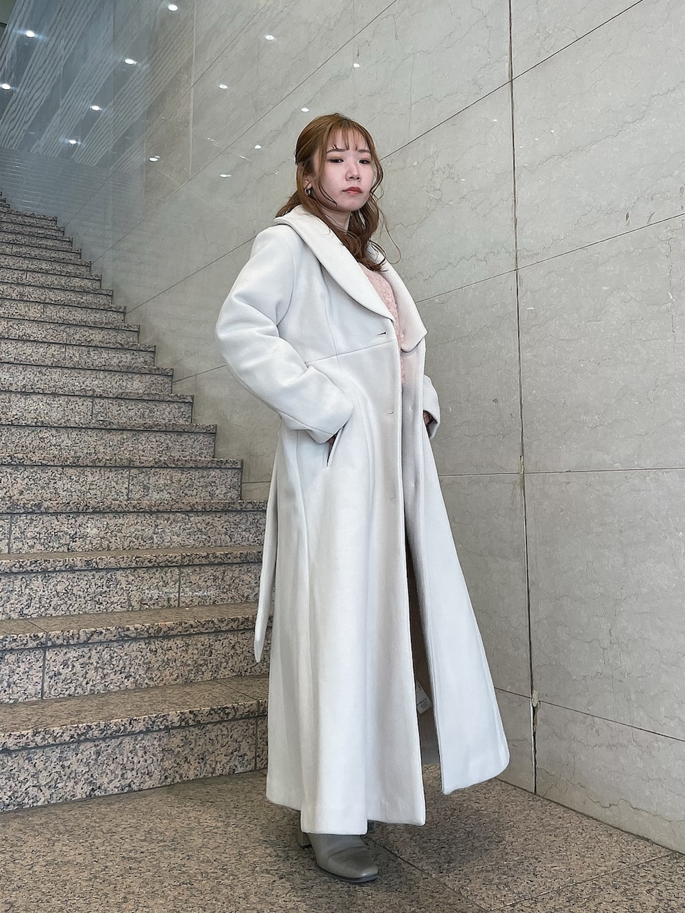 ブラウン系のブーツ、レッド系のニット/セーター、ホワイト系のその他アウターを着用したレディースの冬コーディネートの2枚目の写真