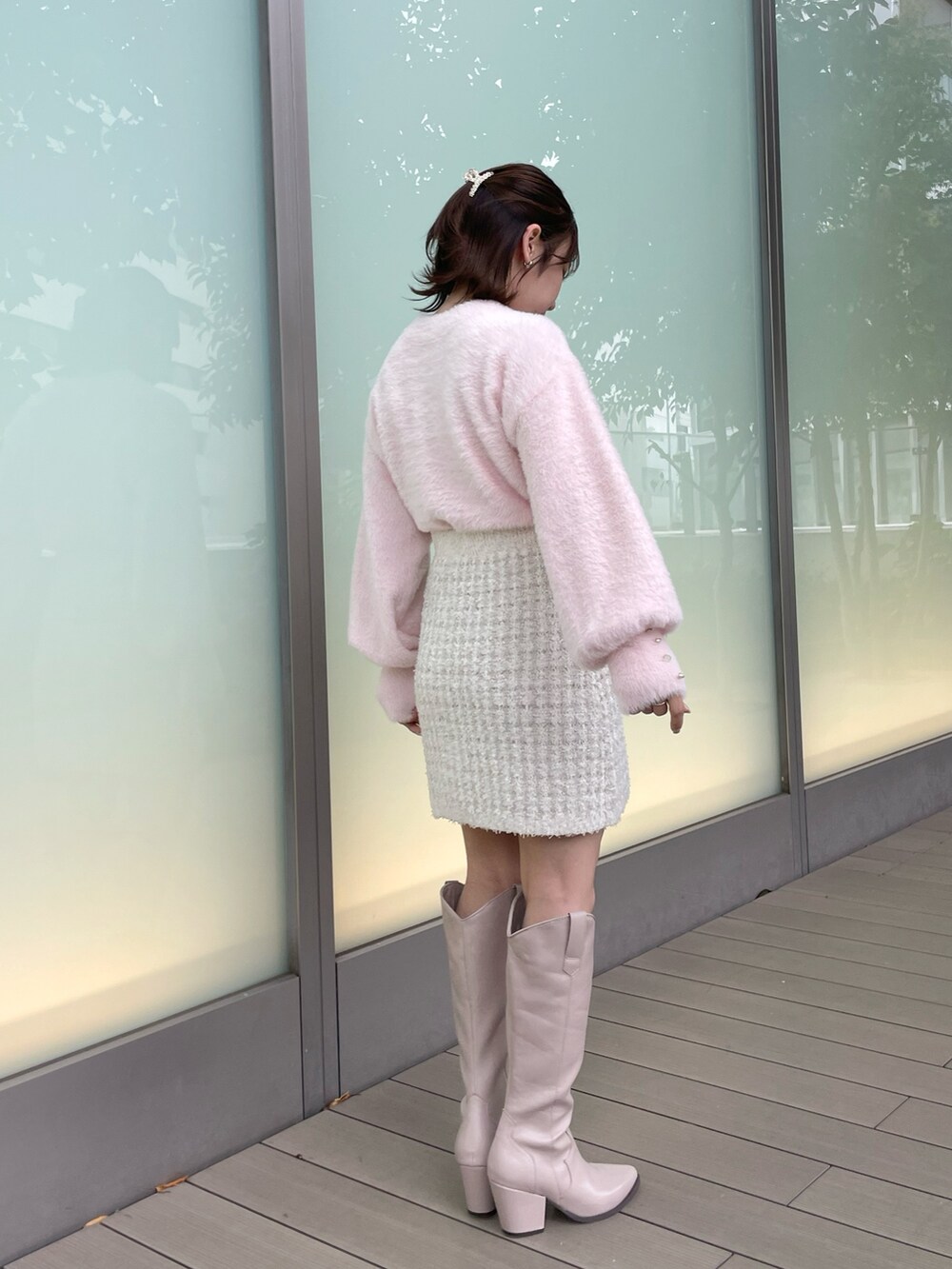 ピンク系のニット/セーター、ホワイト系のスカート、ベージュ系のブーツを着用したレディースの秋コーディネートの5枚目の写真