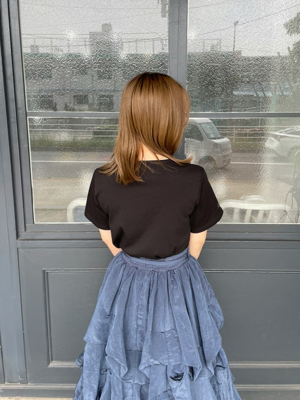 ブラック系のTシャツ/カットソー、ブラック系のかごバッグ、ブルー系のスカートを着用したレディースの夏コーディネートの5枚目の写真