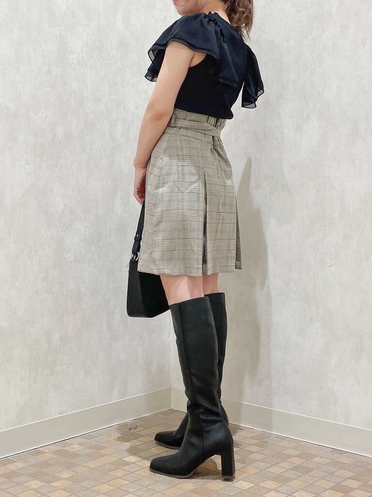 ブラック系のハンドバッグ、ブラック系のTシャツ/カットソー、グレー系のスカートを着用したレディースの夏コーディネートの2枚目の写真