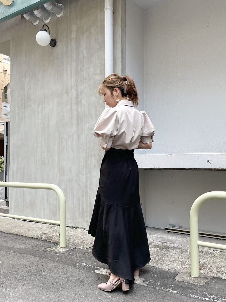 ベージュ系のシャツ/ブラウス、ブラック系のスカート、ピンク系のパンプスを着用したレディースの夏コーディネートの3枚目の写真