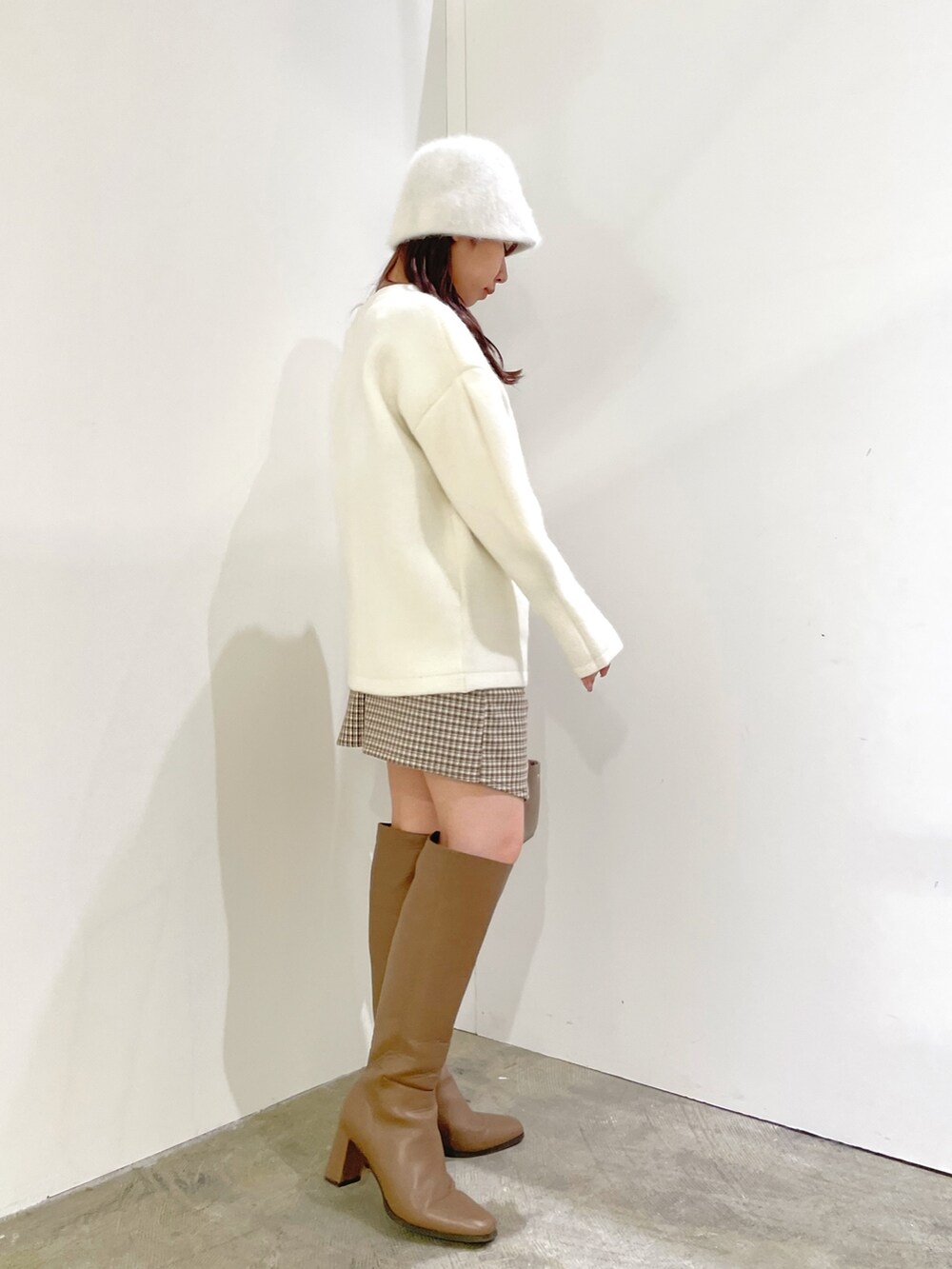 ホワイト系のカーディガン/ボレロ、ブラウン系のスカート、ベージュ系のブーツを着用したレディースの夏コーディネートの3枚目の写真