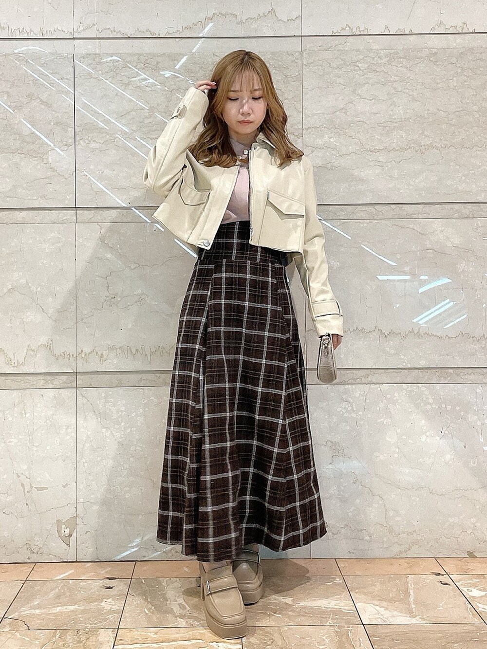 ホワイト系のライダースジャケット、ピンク系のシャツ/ブラウス、ブラウン系のスカートを着用したレディースの冬コーディネートの4枚目の写真