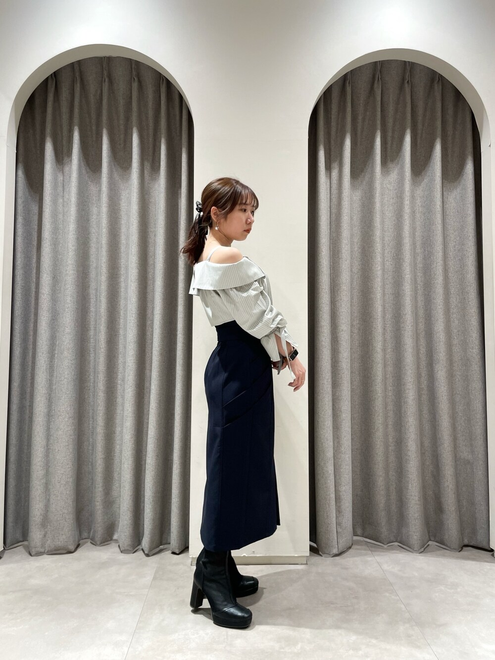 ブルー系のスカート、グレー系のシャツ/ブラウス、ブラック系のブーツを着用したレディースの春コーディネートの3枚目の写真