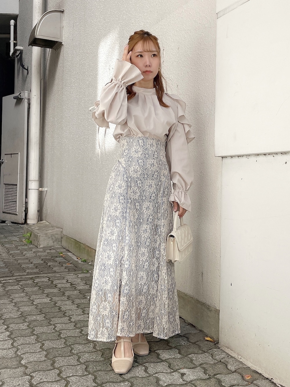 ベージュ系のシャツ/ブラウス、ブルー系のスカート、ホワイト系のパンプスを着用したレディースの冬コーディネートの4枚目の写真