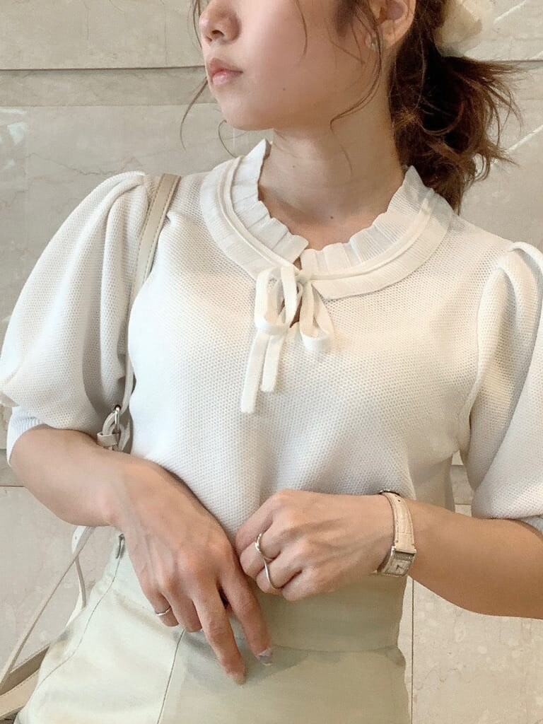 グリーン系のスカート、ホワイト系のパンプス、ホワイト系のハンドバッグを着用したレディースの春コーディネートの5枚目の写真