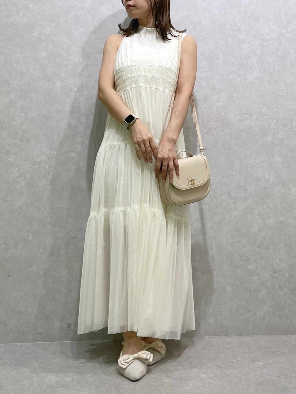 ベージュ系のパンプス、ホワイト系のハンドバッグ、ホワイト系のワンピースを着用したレディースの夏コーディネートの2枚目の写真