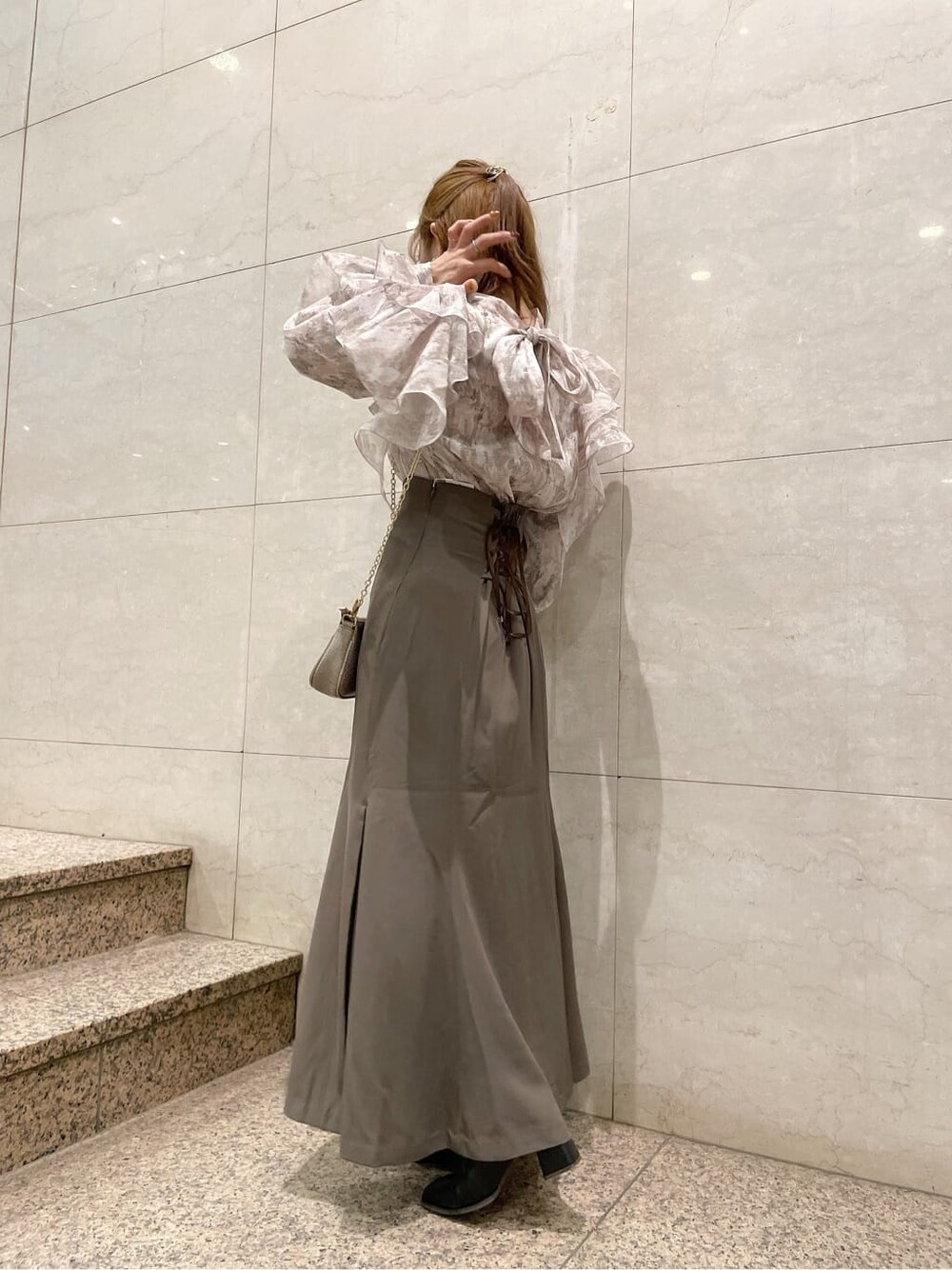 ブラック系のブーツ、ベージュ系のスカート、ベージュ系のシャツ/ブラウスを着用したレディースの秋コーディネートの3枚目の写真