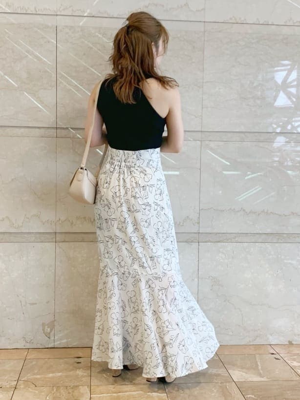 ブラック系のサンダル、ベージュ系のショルダーバッグ、ホワイト系のスカートを着用したレディースの春コーディネートの3枚目の写真