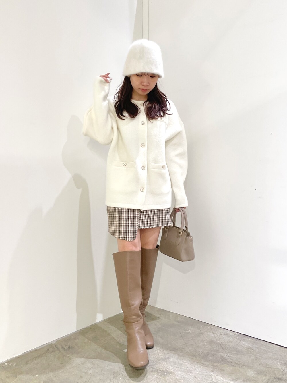 ホワイト系のカーディガン/ボレロ、ブラウン系のスカート、ベージュ系のブーツを着用したレディースの夏コーディネートの2枚目の写真