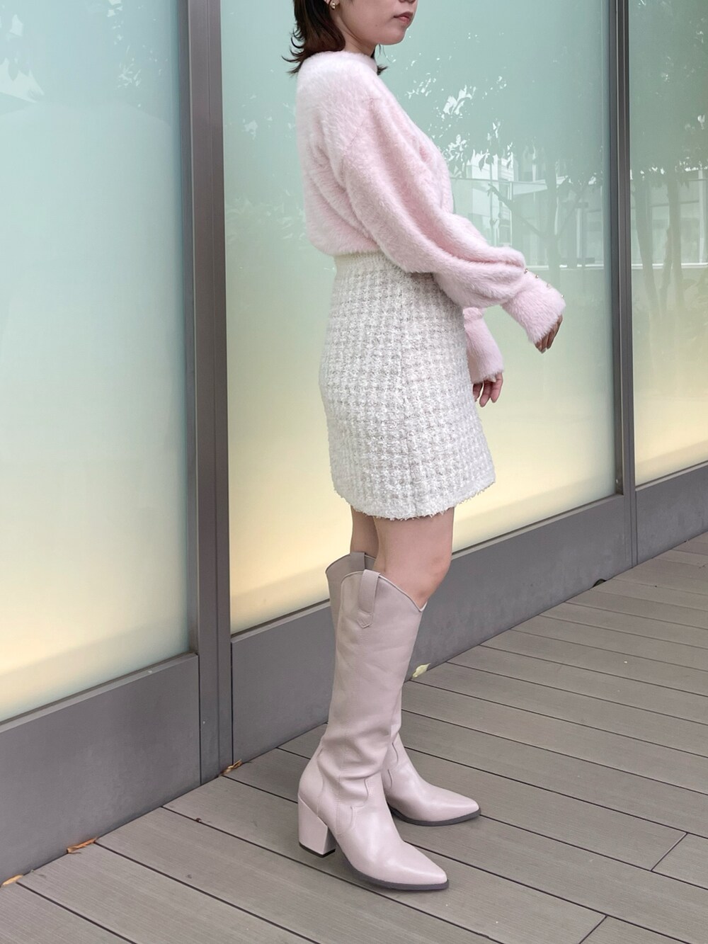 ピンク系のニット/セーター、ホワイト系のスカート、ベージュ系のブーツを着用したレディースの秋コーディネートの4枚目の写真