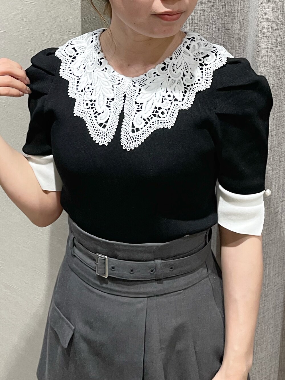 ブラック系のニット/セーター、グレー系のスカート、ブラック系のブーツを着用したレディースの春コーディネートの5枚目の写真