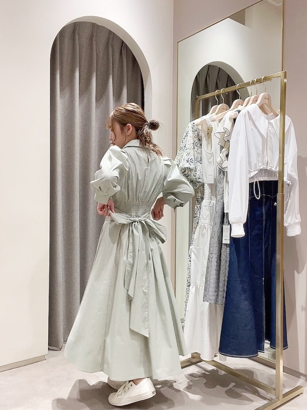 グリーン系のワンピースを着用したレディースの春コーディネートの2枚目の写真