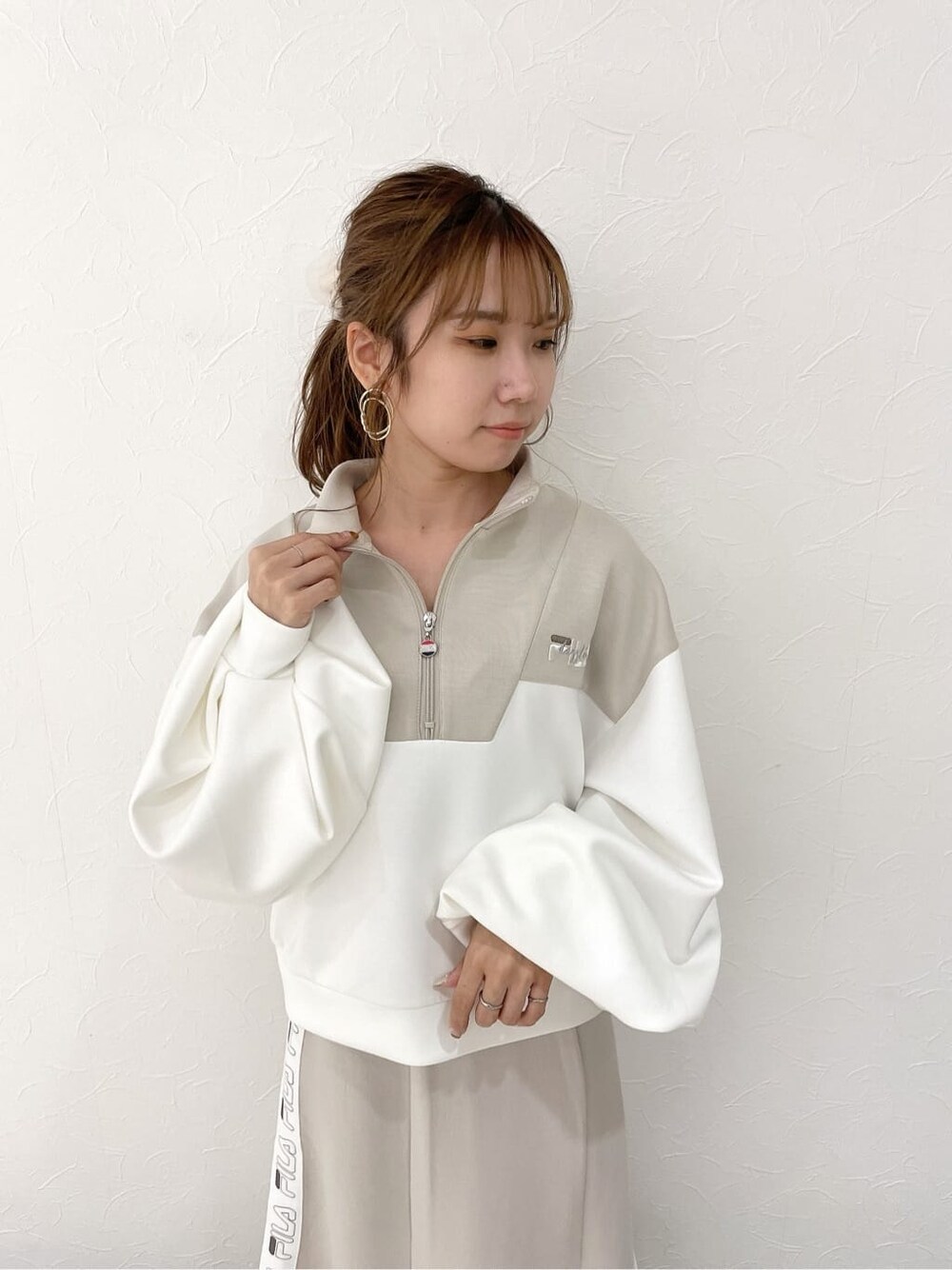 ベージュ系のスカート、ブラック系のブーツ、ベージュ系のTシャツ/カットソーを着用したレディースの秋コーディネートの6枚目の写真