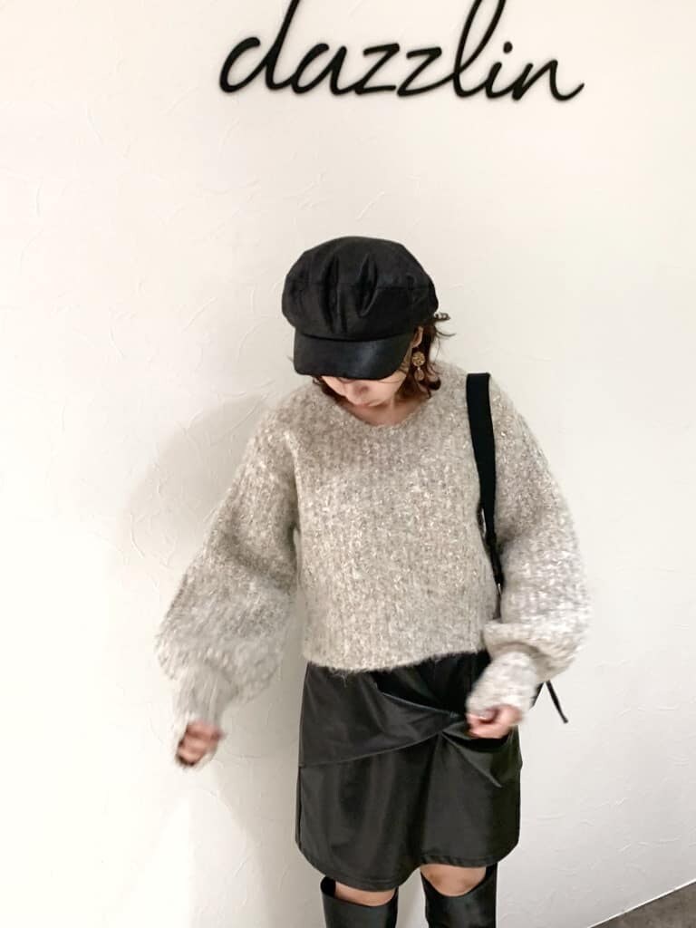 ブラック系のスカート、ブラック系のブーツ、ベージュ系のニット/セーターを着用したレディースの秋コーディネートの6枚目の写真