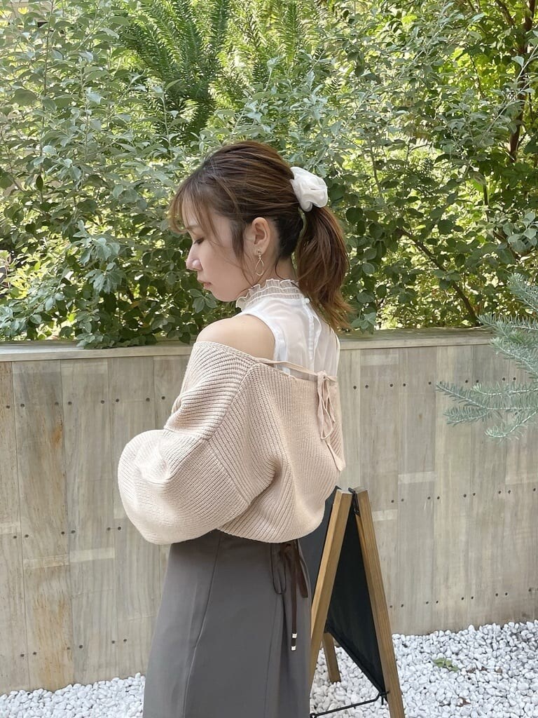 ベージュ系のニット/セーター、ベージュ系のスカート、ベージュ系のブーツを着用したレディースの秋コーディネートの5枚目の写真