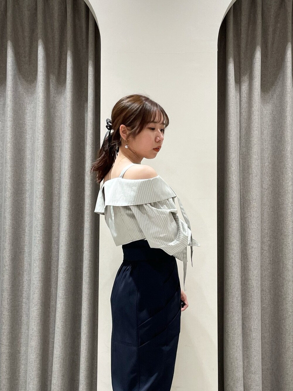 ブルー系のスカート、グレー系のシャツ/ブラウス、ブラック系のブーツを着用したレディースの春コーディネートの6枚目の写真