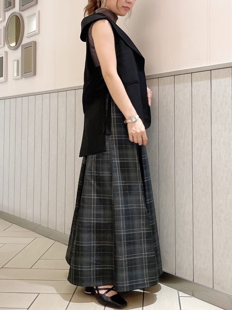 ブラック系のベスト、グレー系のワンピース、ブラック系のパンプスを着用したレディースの夏コーディネートの3枚目の写真